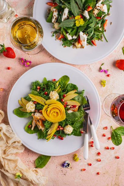 レストランのピンクのテーブルの上のプレートに提供される新鮮な野菜サラダ - 写真・画像
