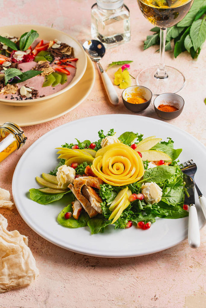 Salada de legumes frescos com peito de frango decorado com frutas esculpidas rosa servida em prato
 - Foto, Imagem