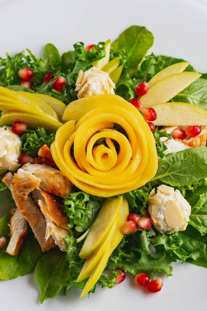 Свіжий овочевий салат з курячими грудьми, прикрашений різьбленою трояндою фруктів
 - Фото, зображення