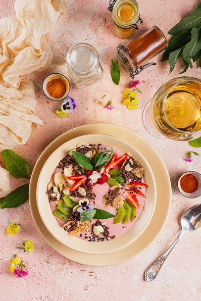 Dolce yogurt alla fragola con frutta fresca in ciotola su sfondo rosa con ingredienti
 - Foto, immagini