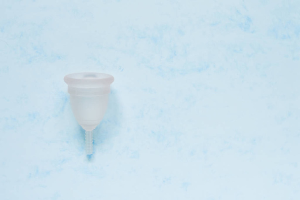 Menstrual cup on blue background. Alternative feminine hygiene p - Fotoğraf, Görsel