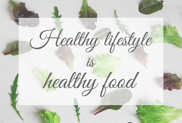 A healthy lifestyle is healthy food. The inscription on the background with salad and arugula. Healthy meal - Photo, image