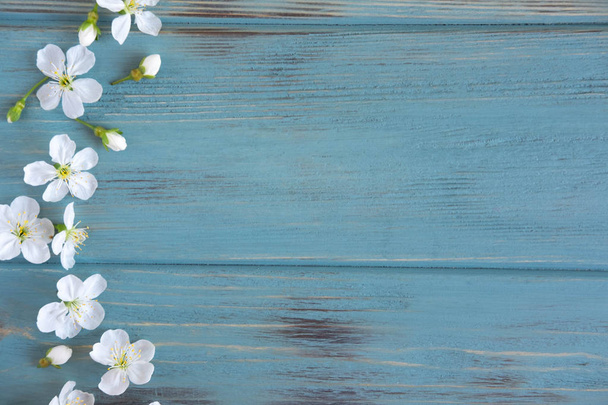 Lentebloemen van kers op een houten achtergrond met een plaats voor een inscriptie. Ontwerp voor wenskaart met kersen bloemen. Sjabloon, leeg voor de lente groet banner, blog post met lentebloem - Foto, afbeelding