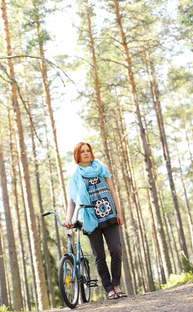 Young beautiful red-haired woman with a bike - Photo, image