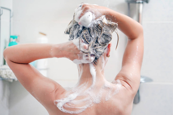 Visão traseira da jovem mulher lavando o cabelo
 - Foto, Imagem