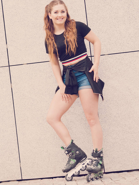 Young woman riding roller skates - Фото, изображение