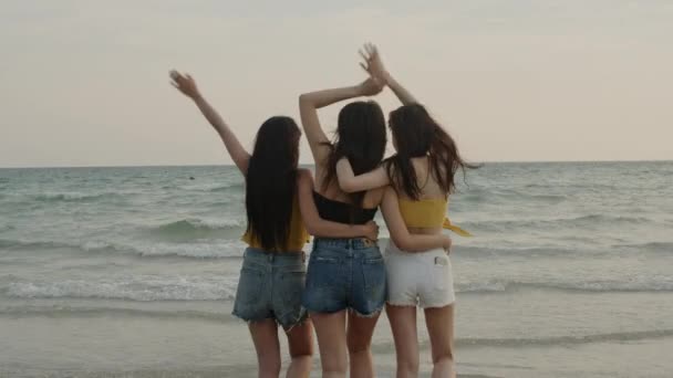 Grupa azjatyckich młodych kobiet chodzenie na plaży, przyjaciele szczęśliwy relaks zabawy grając na plaży w pobliżu morza, gdy zachód słońca wieczorem. Lifestyle przyjaciele podróżować wakacje lato pojęcie. Strzał w zwolnionym tempie - Materiał filmowy, wideo