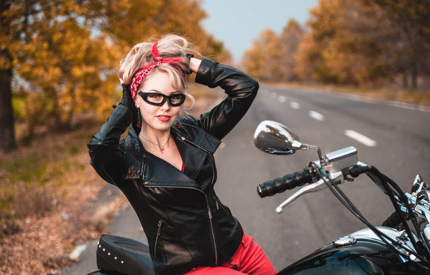 Hermosa mujer motorista posando con la motocicleta al aire libre
. - Foto, imagen