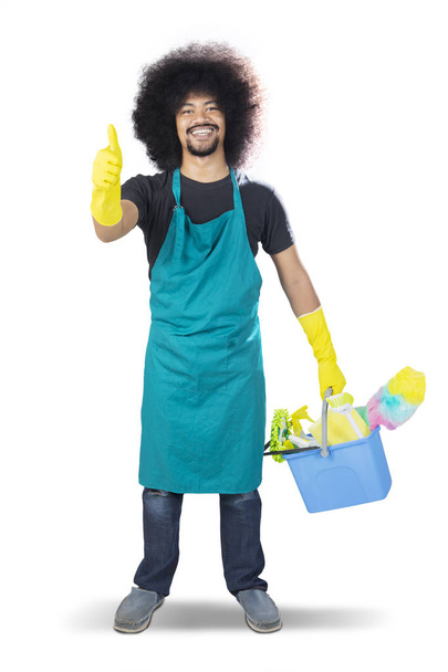 Happy male janitor showing thumbs up on studio - Zdjęcie, obraz