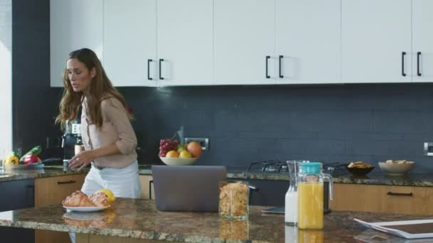 Business woman preparing breakfast in a hurry. Busy person checking mobile phone - Filmagem, Vídeo