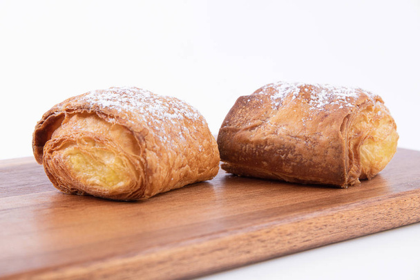 Two freshly baked puff pastry buns with powdered sugar - Photo, Image