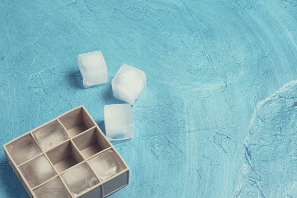 Buz küpleri ve silikon kalıp mavi taş arka planda. Buz prod - Fotoğraf, Görsel