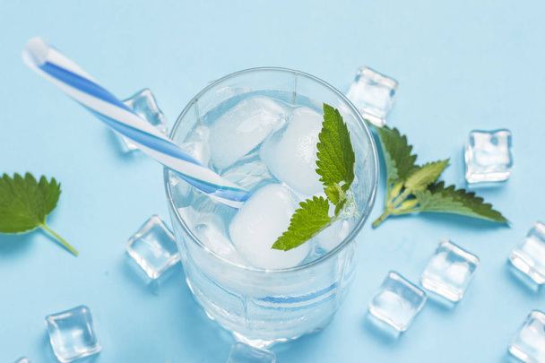 Bicchiere di acqua fredda e rinfrescante con ghiaccio e menta su una b blu
 - Foto, immagini