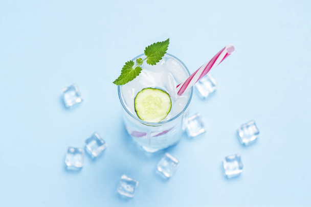 Glas koud en verfrissend water met ijs, munt en komkommer o - Foto, afbeelding