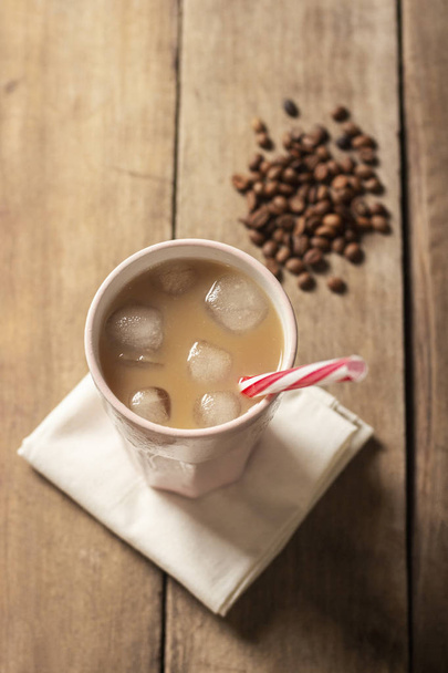 Освежающий и бодрящий холодный кофе в стакане на деревянном бэкгре
 - Фото, изображение