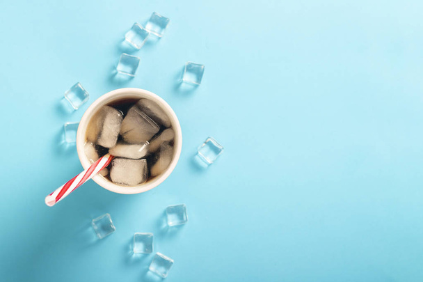 Refreshing iced coffee in a glass and ice cubes on a blue backgr - Foto, Bild