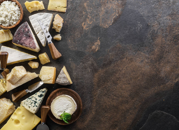 Assortment of organic cheeses on stone background. Top view. Tas - Φωτογραφία, εικόνα