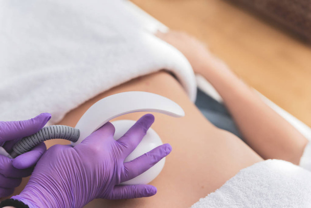 Close up of woman having multipolar radiofrequncy treatment for body shaping and tightening on her belly  - Φωτογραφία, εικόνα