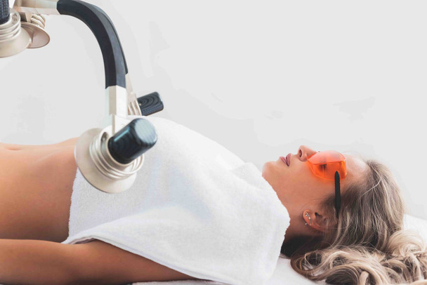 Female patient having modern laser body shaping treatment in beauty center  - Φωτογραφία, εικόνα