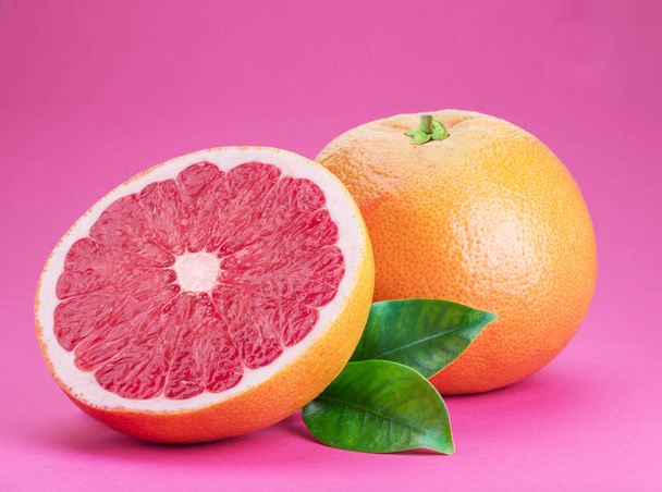 Grapefruit and grapefruit slice isolated on pink background. - Photo, image