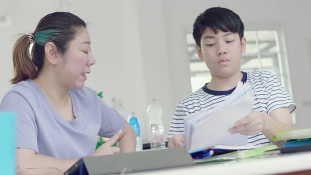 A szigorú ázsiai anya ellenőrzi a fia nevelésében. A fiú bűnösnek találták a házi feladatot. Az anya, aki törődik a gyermek tanulási - Felvétel, videó