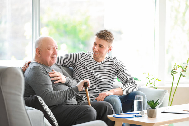 Male caregiver with senior man in nursing home - Foto, immagini