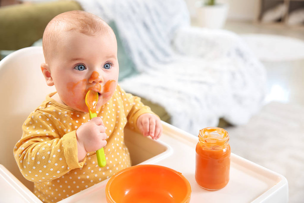 Niedliches kleines Baby isst leckeres Essen zu Hause - Foto, Bild