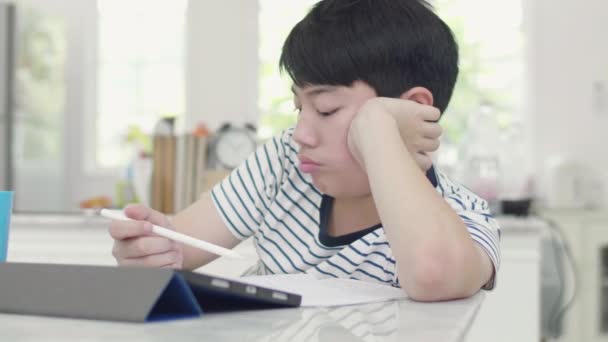 De slecht getemperde Aziatische jongen deed zijn huiswerk met behulp van een Tablet PC om informatie te vinden - Video