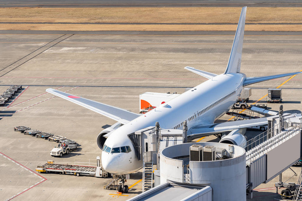 White Airplane unloading and loading passenger at Jet bridge in airport - Фото, зображення