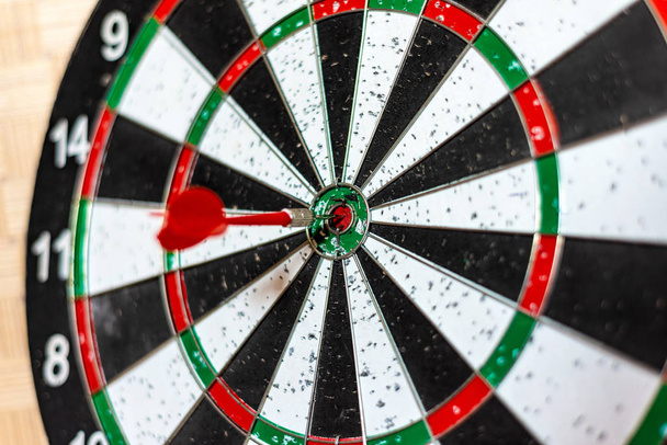 A round board for playing darts close up, a red dart hit the target. - Photo, Image