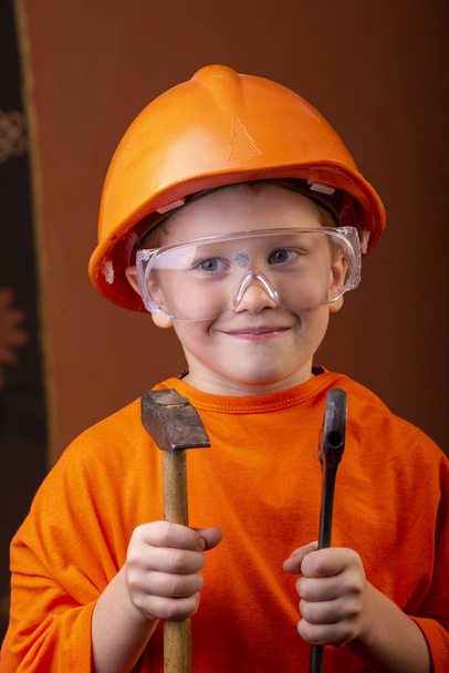 boy builder in an orange helmet - Фото, изображение