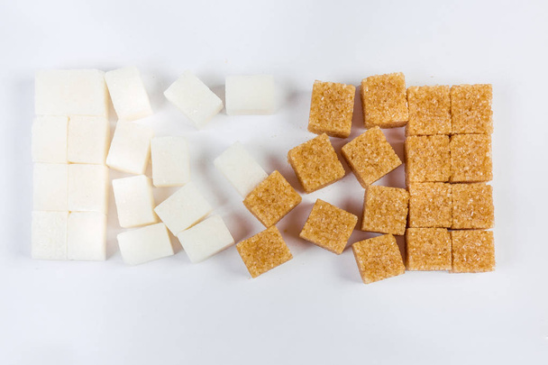 White and brown sugar cubes on a light surface - Photo, Image
