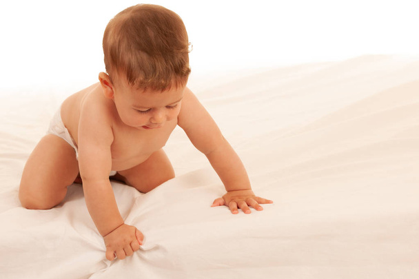 Hapy baby boy in playing on bed isolated over white  - Foto, Bild