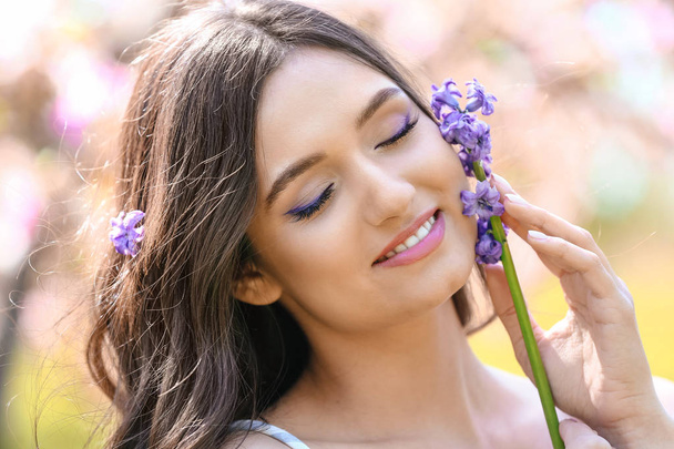 Beautiful young woman with hyacinth flowers outdoors - Photo, Image