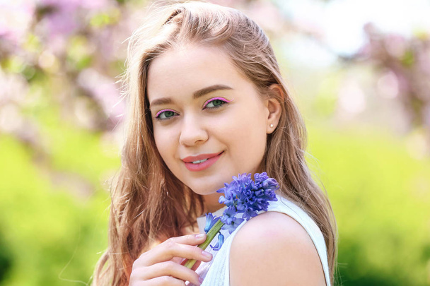 Hermosa mujer joven con flores de jacinto al aire libre
 - Foto, imagen