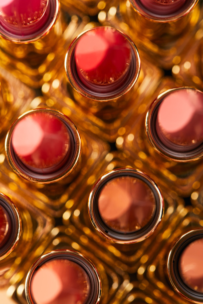 Top uitzicht van verschillende rode tinten van lippenstift in tubes  - Foto, afbeelding