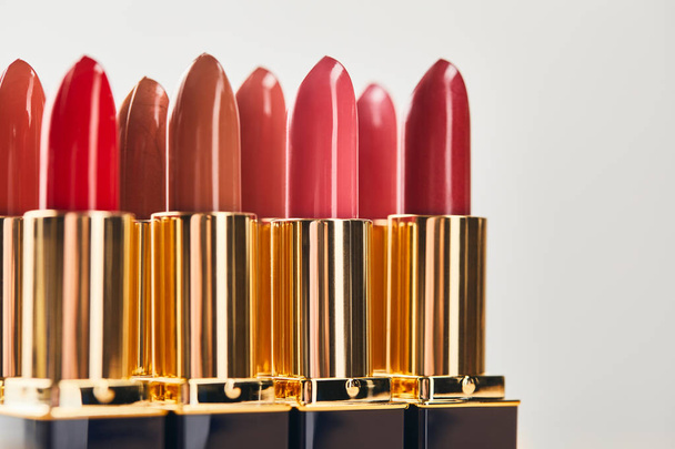 selective focus of various red shades of lipsticks isolated on grey  - Foto, Bild