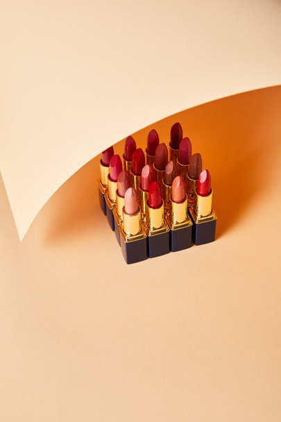 various red shades of lipsticks on beige  - Foto, Bild