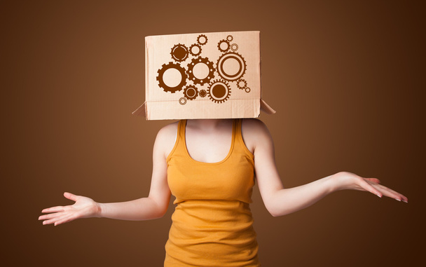 Young woman gesturing with a cardboard box on his head with spur - Фото, зображення