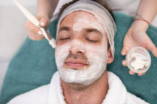 Man getting a face treatment at the health spa - Foto, imagen