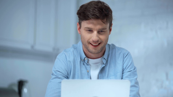 vue de face de pigiste en chemise bleue ouverture ordinateur portable et dactylographier avec un sourire sincère
 - Séquence, vidéo