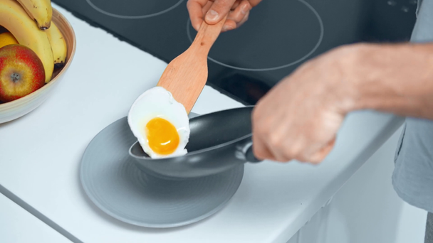 részleges kilátás az ember főzés rántottát tojás a reggeli konyhában - Felvétel, videó