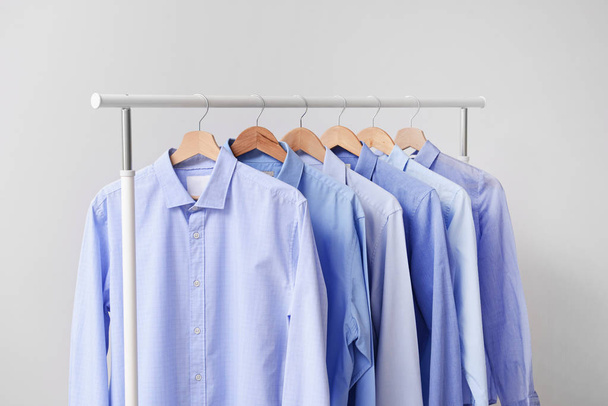 Rack with clothes after dry-cleaning on light background - Photo, Image