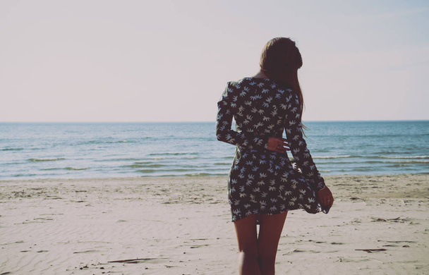 Fiatal lány a tengerparton. A finn-öböl partja. Esti, napsütéses Időjárás. - Fotó, kép