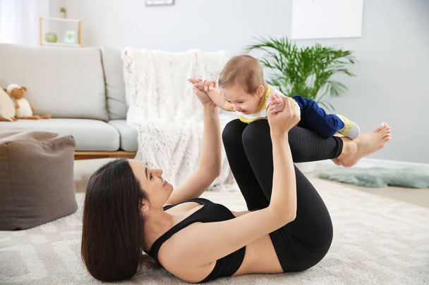 Madre entrenamiento con lindo bebé en casa
 - Foto, imagen