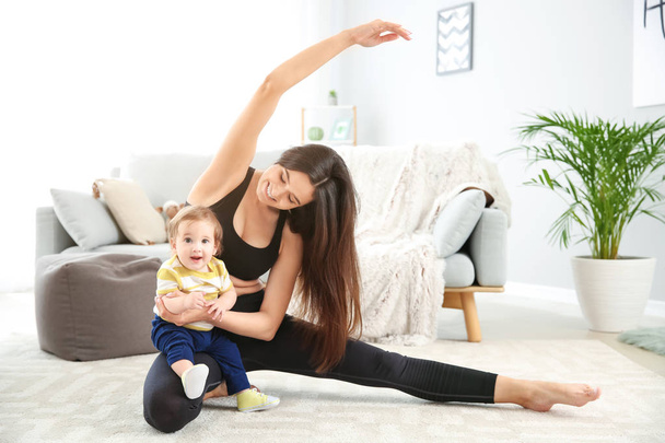 Mãe de treinamento com bebê pequeno bonito em casa
 - Foto, Imagem