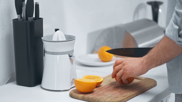 a narancs vágására az ember részleges nézete a konyhában - Felvétel, videó