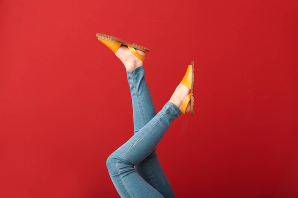 Legs of young woman in stylish shoes on color background - Foto, Imagem