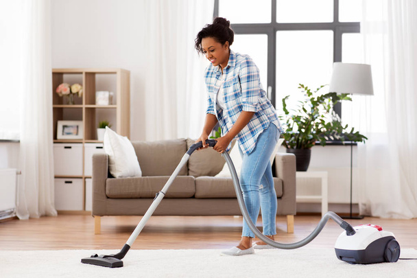 woman or housewife with vacuum cleaner at home - Foto, immagini