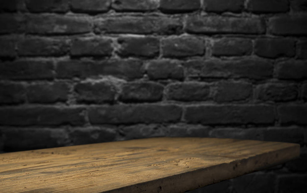 Old wood table with blurred concrete block wall in dark room background. - Foto, Bild
